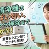 空気清浄機の酸っぱい匂い対策について解説するブログ記事のアイキャッチ画像。驚き、そして安堵の表情を浮かべた日本人女性が、清潔になったフィルターを持っている。画像内には、「空気清浄機の酸っぱい匂い、原因から掃除まで丸わかり!」「重曹&クエン酸でスッキリ解決!」というテキストが、爽やかなグリーンとブルーを基調としたエフェクトとともに入っている。背景には、清潔なリビングルームと、運転中の空気清浄機が見える。