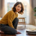 ロボット掃除機と笑顔で並ぶ、日本人女性。清潔で明るいリビングルーム。